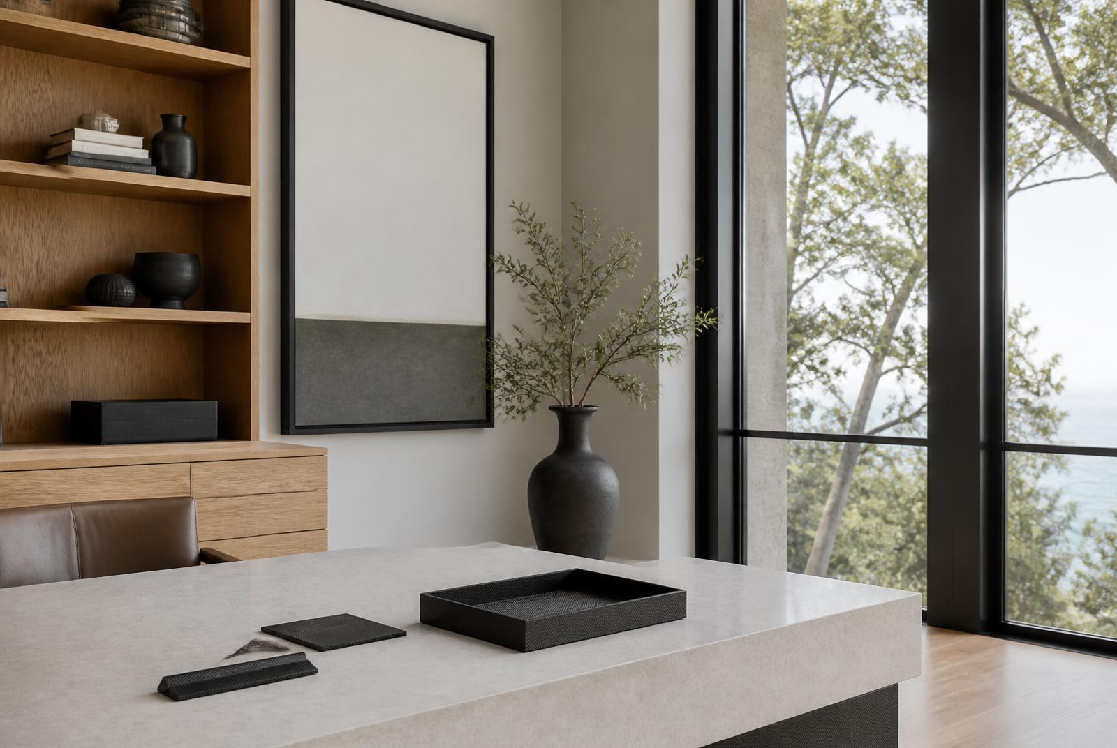 Private study with stone desk and carbon fibre desk objects beside a tall window